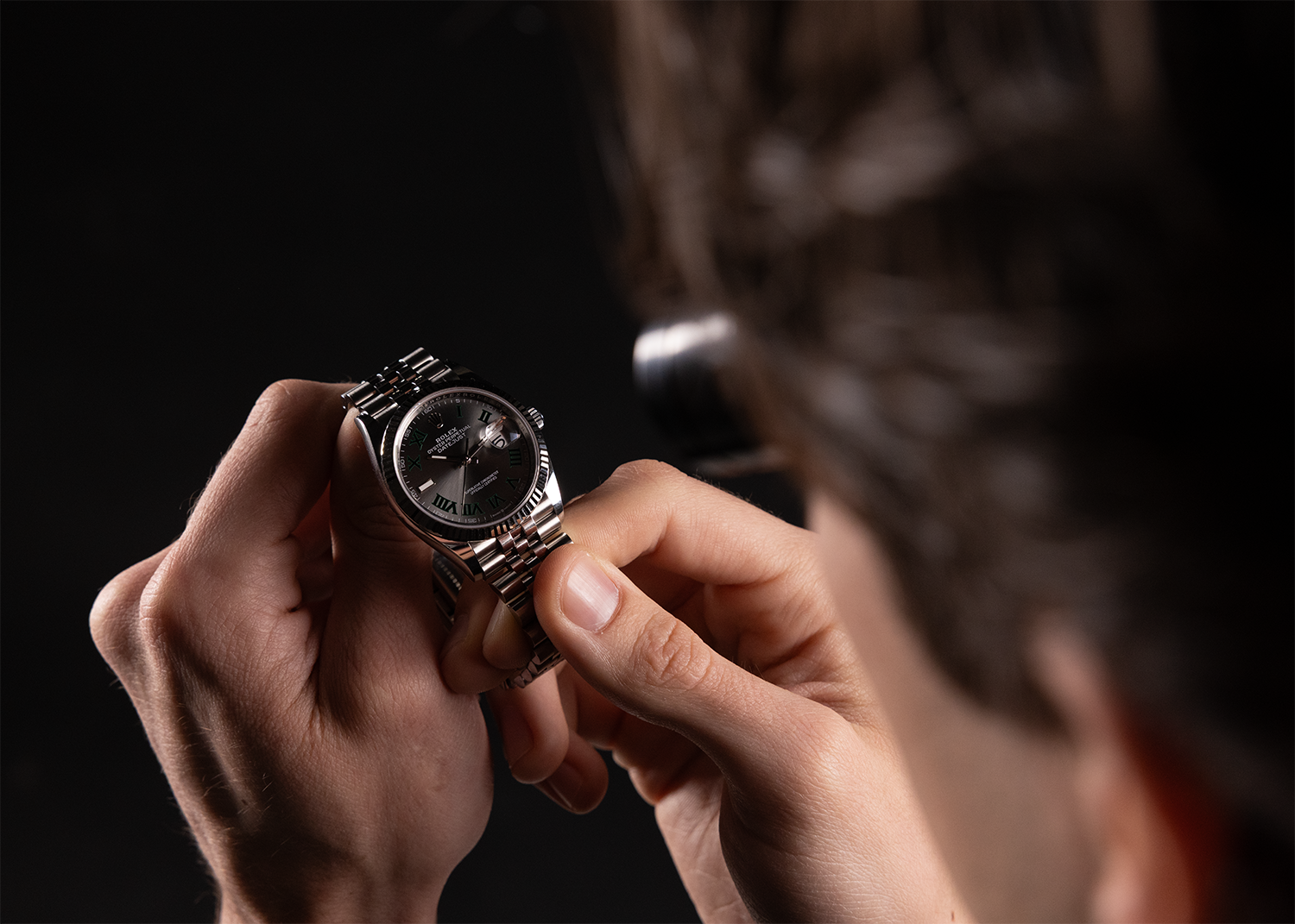 Représentation d'une expertise rolex. Homme inspectant une rolex datejust wimbledon.